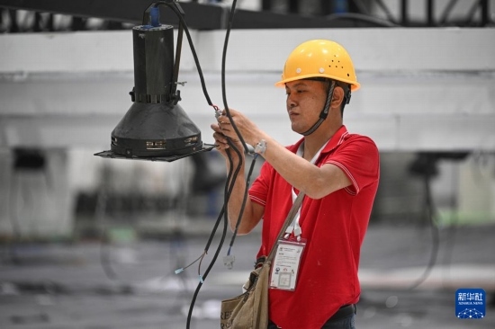 4月4日，工作人員在海南國(guó)際會(huì)展中心內(nèi)布設(shè)燈光。