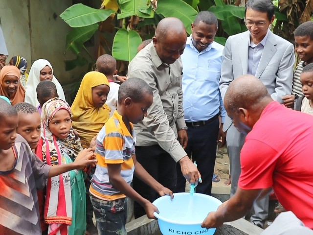 在日前舉行的安全供水工程揭牌儀式上，當(dāng)?shù)匦∨笥言诠┧c(diǎn)接水。 施亮攝