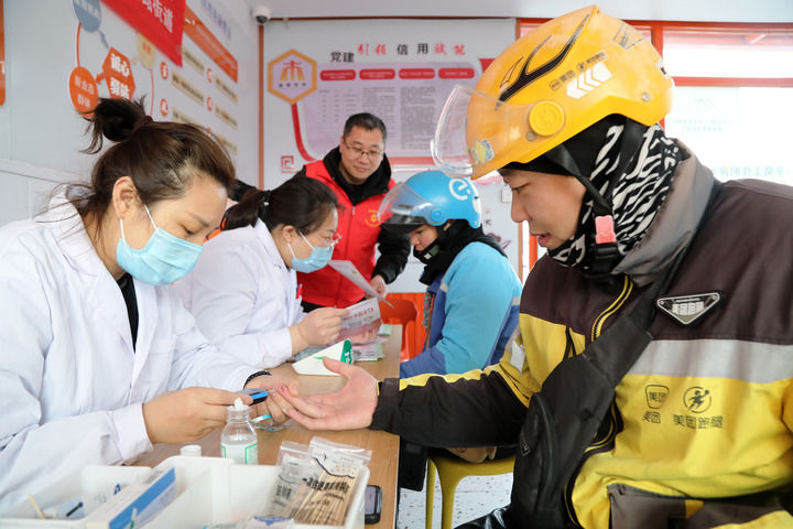 2025年3月5日，志愿者在山東省棗莊市市中區(qū)一工會(huì)驛站為外賣員免費(fèi)測量血糖。新華社發(fā)（王海楠攝）