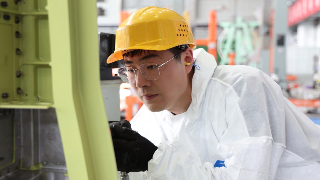 在中國(guó)航空工業(yè)集團(tuán)成飛車間內(nèi)，飛機(jī)鉚裝鉗工首席操作技師馮攀龍正在工作。（新華社發(fā)）