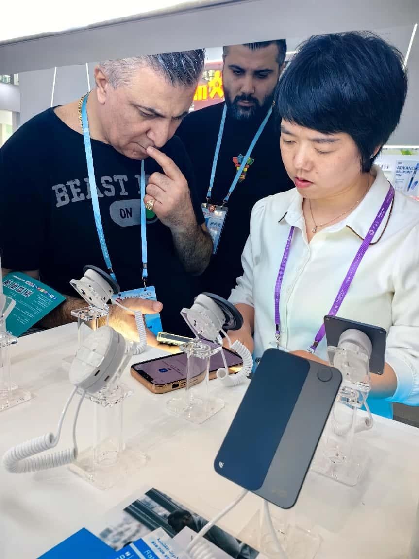 展臺工作人員向外商展示“AI TOP翻譯終端”。圖片來源：受訪者提供