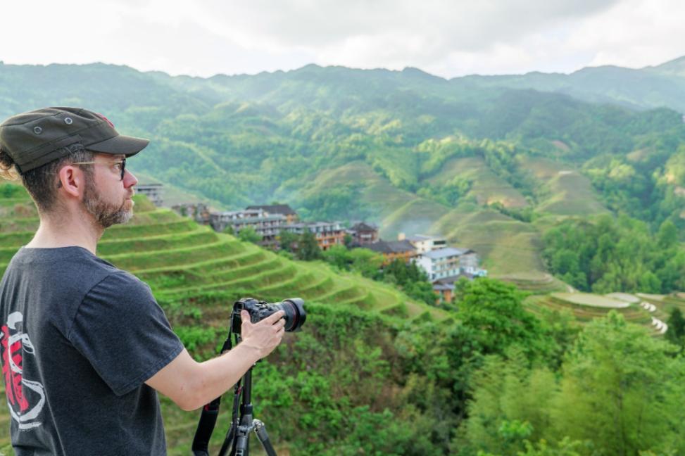 2025年年5月9日，廣西桂林，外國游客游覽龍脊梯田，在美景前駐足拍照。（圖片來源：視覺中國）