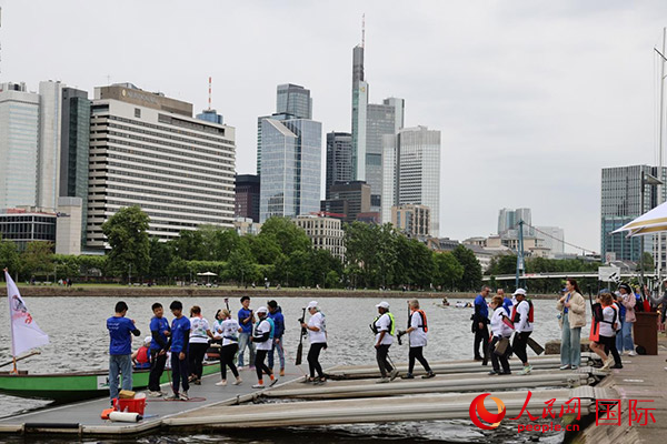 來(lái)自美國(guó)的快樂(lè)龍舟隊(duì)選手們正在登船準(zhǔn)備參賽。人民網(wǎng)記者 劉仲華攝