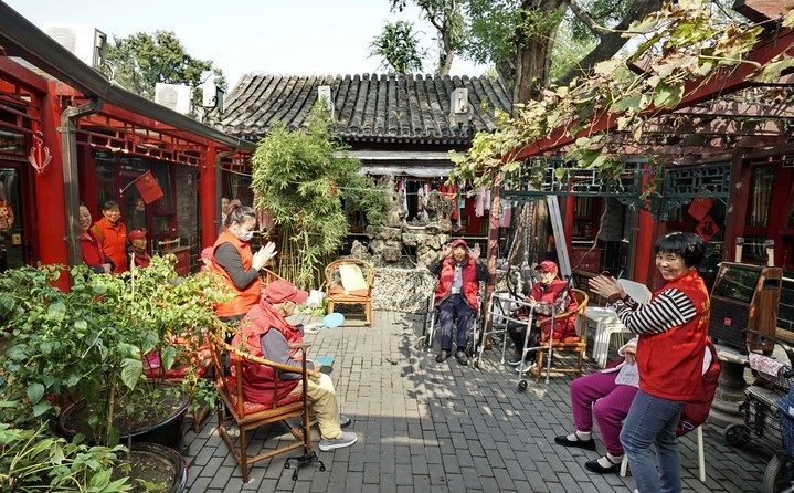 2024年10月12日，鐘樓灣胡同的老年人在社區(qū)內(nèi)的四合院養(yǎng)老驛站休閑。2017年起，北京市先后開展了兩輪背街小巷環(huán)境整治提升行動(dòng)，完整保留了中軸線生活建筑群的歷史信息，并根據(jù)居民的生活和居住方式進(jìn)行適配化的更新和改造，極大地改善了生活環(huán)境。2023年鐘樓灣胡同被評為“北京最美街巷”。