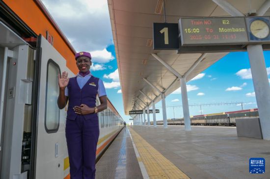 5月31日，在蒙內(nèi)鐵路內(nèi)羅畢站，一名乘務(wù)員在即將開(kāi)往蒙巴薩的E2次列車(chē)旁等候乘客。新華社記者 楊光 攝