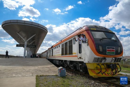 5月31日，在蒙內(nèi)鐵路內(nèi)羅畢站，機(jī)車(chē)駕駛員蔣立平（右）和博爾在即將開(kāi)往蒙巴薩的E2次列車(chē)上揮手致意。新華社記者 楊光 攝